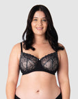 Olivia elegantly showcases Hotmilk's award-winning flexi underwire maternity and nursing bra, Temptation in Black. This versatile everyday black lace full cup bra provides ample lift and support. With fully adjustable straps, it's suitable for both date nights and all-day wear, making it an ideal choice for breastfeeding mothers