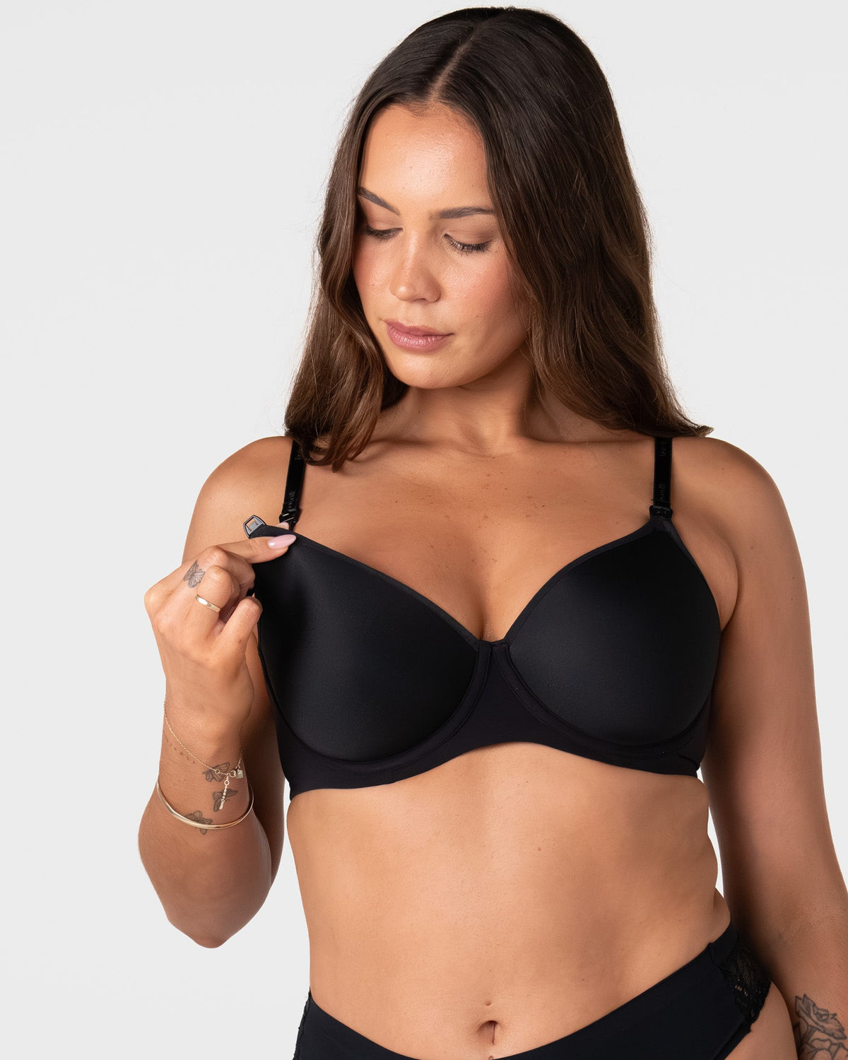 Model unclipping the traditional nursing clip on the Forever New black breastfeeding bra with drop-down cup for easy feeding access