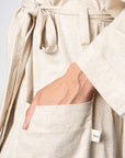 Experience a close-up view of Hotmilk's opulent Linen Blend Robe, showcasing deep pockets, a tie waist, and stylish 3/4 kimono-style sleeves. This robe serves as the perfect addition to Hotmilk's mix-and-match maternity and postpartum loungewear collection, tailored for both breastfeeding and nursing mothers